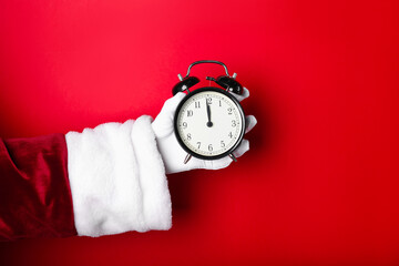 Santa Claus with alarm clock on red background, closeup with space for text. New Year greeting card