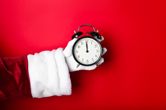 Santa Claus with alarm clock on red background, closeup with space for text. New Year greeting card