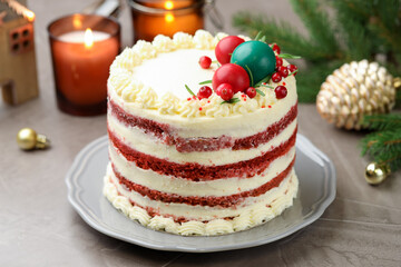 Delicious sponge cake with Christmas decor and red currants on grey textured table, closeup