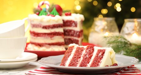 Slice of tasty cake with cranberries served on white table against blurred lights, closeup. Christmas dessert