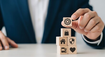 Businessman stacking wooden blocks with icons representing business