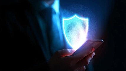 Person holding smartphone with glowing digital shield emerging, signifying cybersecurity and data protection in a modern world. - Powered by Adobe