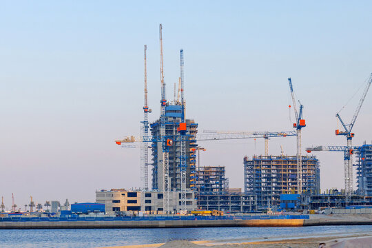 Dubai construction scene with cranes and skyscrapers under development. Symbol of Dubai growth, progress, and modern architecture rising by the waterfront