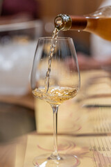 Pouring white wine into a glass during tasting