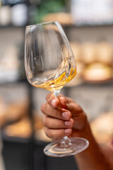 Hand swirling white wine for tasting and aroma