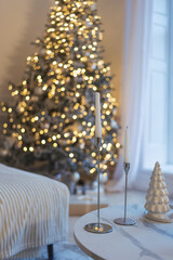 Modern Christmas interior with decorated tree and elegant white decor on coffee table