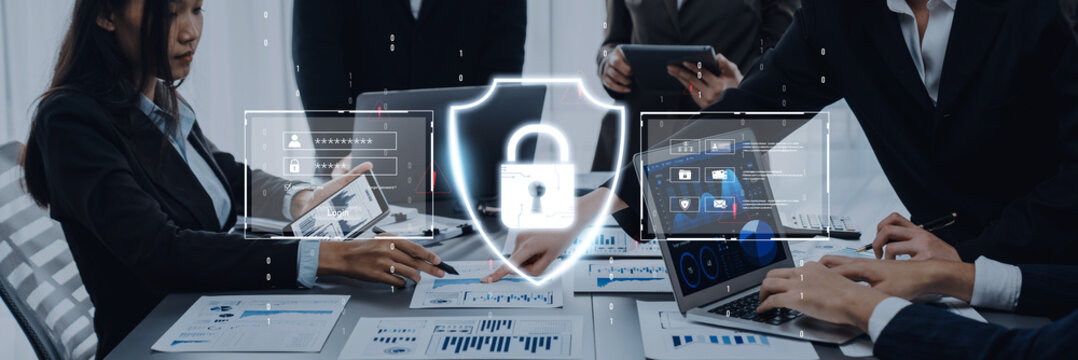 Business professionals engage in a meeting focused on cybersecurity strategies, discussing data protection methods with digital symbols at a conference table. Trope