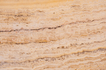 Textured beige marble surface with natural patterns and earthy tones