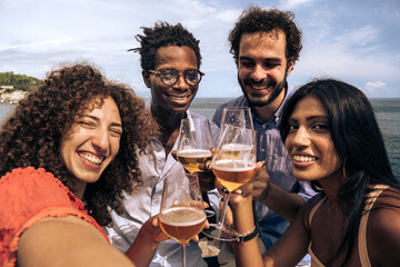 Friends celebrating life by the sea with craft beers in hand under a sunny sky during a perfect summer afternoon