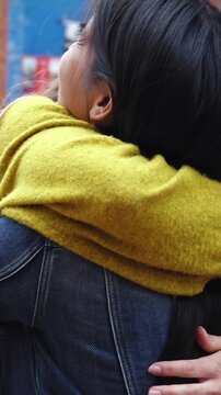 Two happy female university students meet again on campus and hug each other