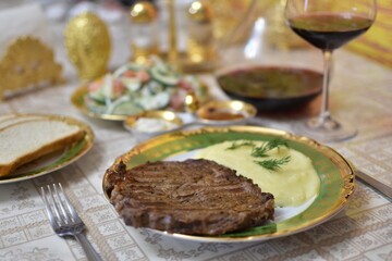 Grilled steak and red wine in a glass decanter on a wooden table