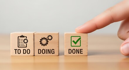 Hand finger pressing the done button on a wooden block, representing project completion and task management