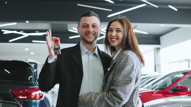 Happy couple celebrates successful car purchase at the dealership - Powered by Adobe