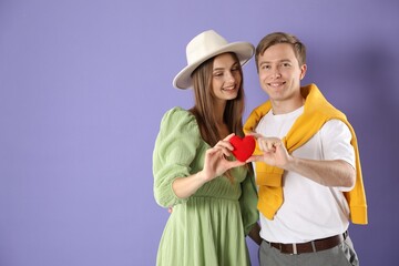 Cute couple with heart figure on violet background, space for text. Romantic date