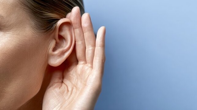 Woman with her hand covering her ear. Concept of privacy and intimacy, as the woman is trying to block out external noise