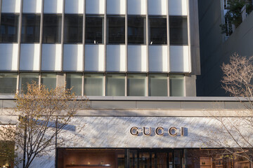 Fototapeta premium wide view of building and sign outside Gucci, a boutique with luxury brand merchandise, located at 130 Bloor St W, Suite 102, Toronto
