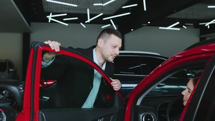 Happy couple in automobile dealership looking for new car in automobile dealership