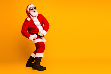 Santa in red suit dancing happily against a bright yellow background for Christmas season celebration and festive mood