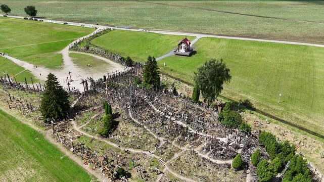 Hill of Crosses, Siauliai, Lithuania &mdash; August 1, 2025: Panoramic aerial footage captured by drone. The scene shows thousands of wooden and metal crosses, walking paths and the surrounding countryside 