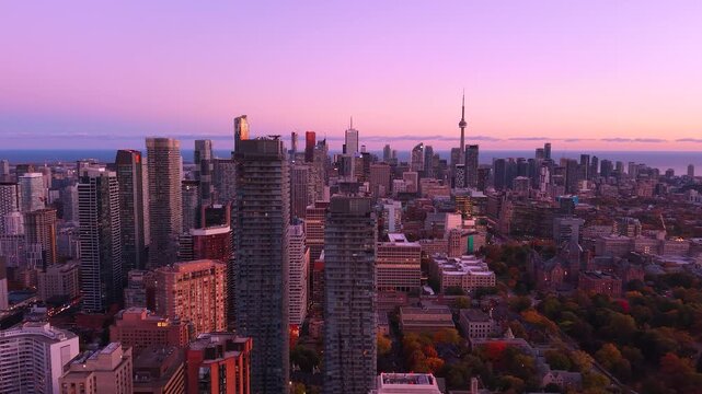 Spectacular purple panoramic evening drone view of modern Downtown skyscrapers and Lake Ontario in Toronto, Ontario, Canada.