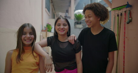Teenagers laughing and smiling together in a suburban alleyway, enjoying carefree moments, multicultural group bonding, representing friendship and youthful energy