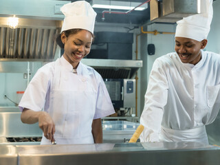 professional chefs white uniform work together clean, modern commercial kitchen. focus prepare various dishes surrounded stainless steel appliances and fresh ingredients. scene high culinary teamwork