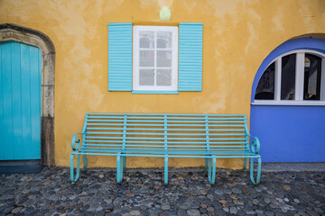 An aqua colored bench in Portmerion.