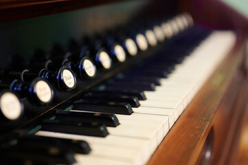 close-up of vintage organ keyboard with selective focus highlights nostalgic musical instrument details and craftsmanship. ideal for music education and antique enthusiasts.