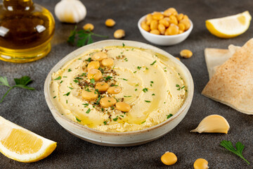 Creamy lupini bean hummus with olive oil, garlic, lemon and herbs in a ceramic bowl. Healthy vegan dip. Close-up.