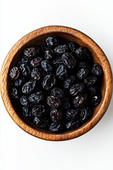 A round bowl filled with shiny dark brown raisins on a light gray background.