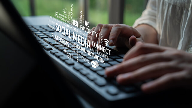 A close-up view of hands typing on a keyboard, surrounded by floating social media icons, symbolizing modern communication and digital connectivity in a bright workspace. Tessel