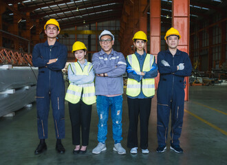 group five industrial worker standing together in factory setting, wearing safety helmets and reflective vest. image represent teamwork, safety compliance, professionalism in industrial environment.