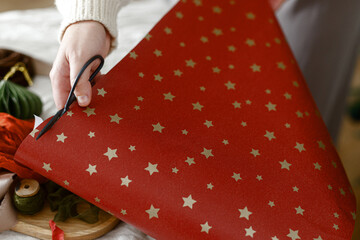 Wrapping christmas presents. Hands packing stylish christmas gift boxes on table with festive...
