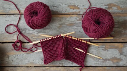 Burgundy Yarn Knitting Project in Progress with Wooden Needles on Rustic Weathered Wood Surface, Craft Hobby Still Life - Powered by Adobe
