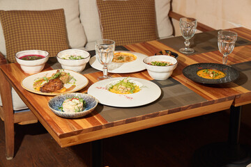 An assortment of gourmet dishes beautifully presented on a rustic wooden dining table