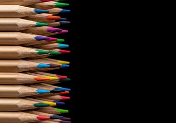 Colored pencils stacked diagonally on black background for artistic creativity and school supply concept, education and drawing activity.