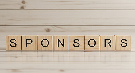 Wooden blocks spelling sponsors arranged on a light wooden surface ideal for business marketing and promotional material backgrounds