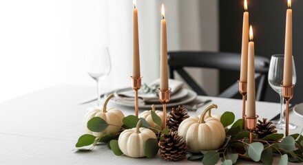 Sophisticated fall table decoration featuring white pumpkins, lit taper candles in copper holders, pinecones, and eucalyptus leaves on white tablecloth