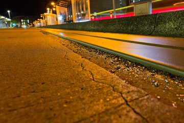 Night view of tram or bus rail at ZOB Flensburg city center with warm street lights