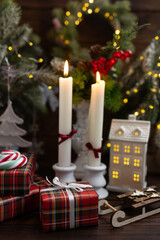 New Year's table setting with white candles and an elegant Christmas tree in the background. A festive and New Year's atmosphere.