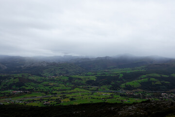 Naklejka premium Scenic mountain valley landscape under cloudy sky in green countryside
