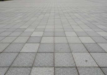 A clean expanse of durable gray granite paving creating a wide, stable sidewalk for pedestrians and general outdoor use, rock, paver, surface
