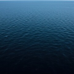 Obraz premium The immense scale of the deep ocean, featuring dark blue water meeting the sky line, representing nature's vastness and endless movement, wild, open, surface