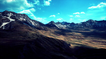 Breathtaking landscape showcases towering mountains bathed in sunlight. Lush valleys stretch below, while wispy clouds dance across the vibrant blue sky, creating a serene and peaceful atmosphere.