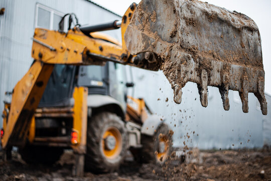 The excavator swings the bucket to dig the soil for pouring the foundation. High quality photo