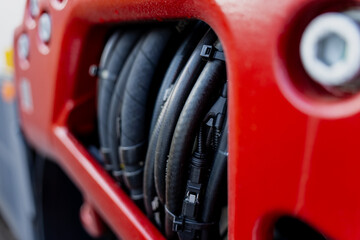 Fototapeta premium Red metal machinery housing with grouped hydraulic hoses representing industrial design, fluid power engineering, and construction equipment maintenance system in modern mechanical assembly