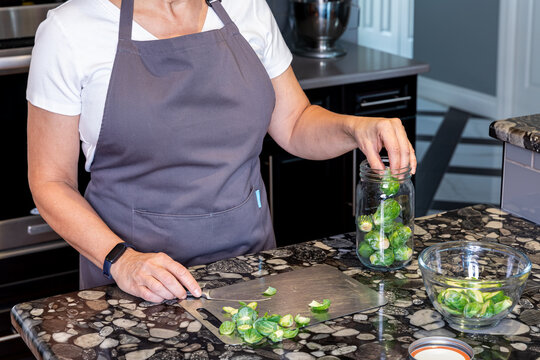 A chef Preparing fresh raw Brussels sprouts for cooking. 