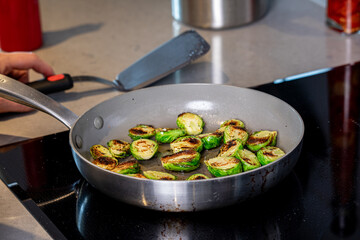 A close up of Brussels sprouts frying in a pan. 