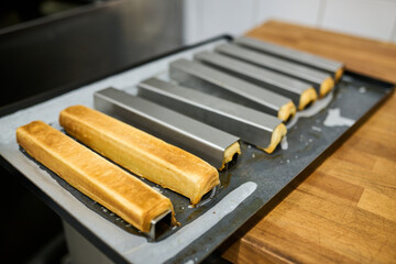 Baking process with rectangular molds on tray, showcasing freshly baked pastries in a modern kitchen environment, emphasizing culinary creativity