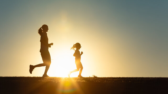 Mother and Child Running at Sunset – Outdoor Fitness and Family Fun